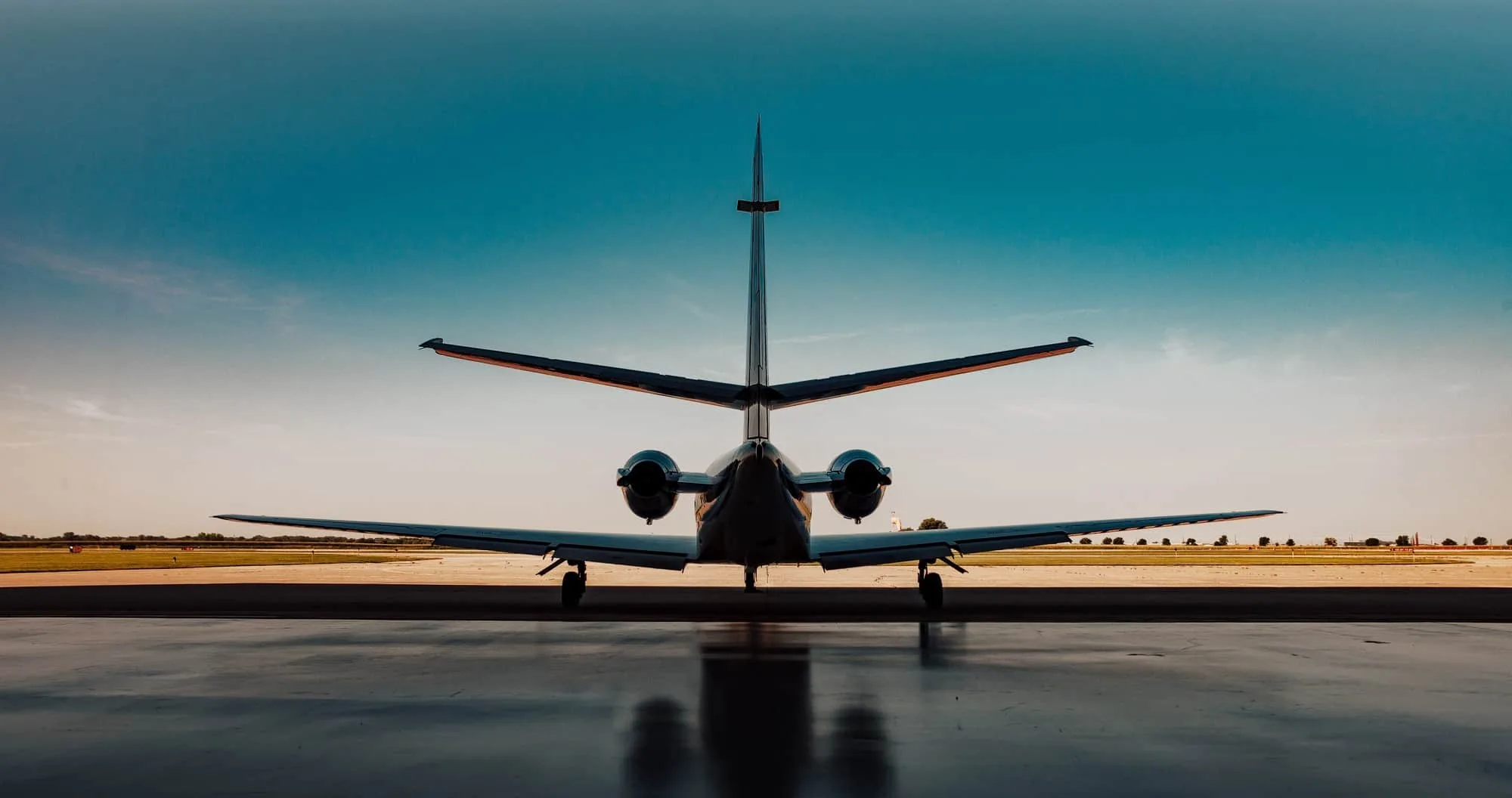 Private jet on the ramp at sunset, seen from behind